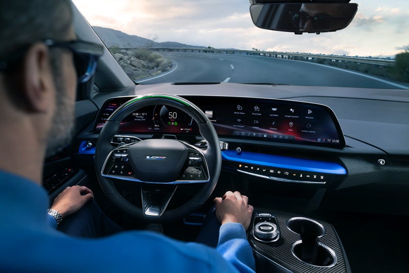 Front View of the 2026 OPTIQ-V Driving Through the Dusk Utilizing its Headlights | Navarre Cadillac in Lake Charles LA